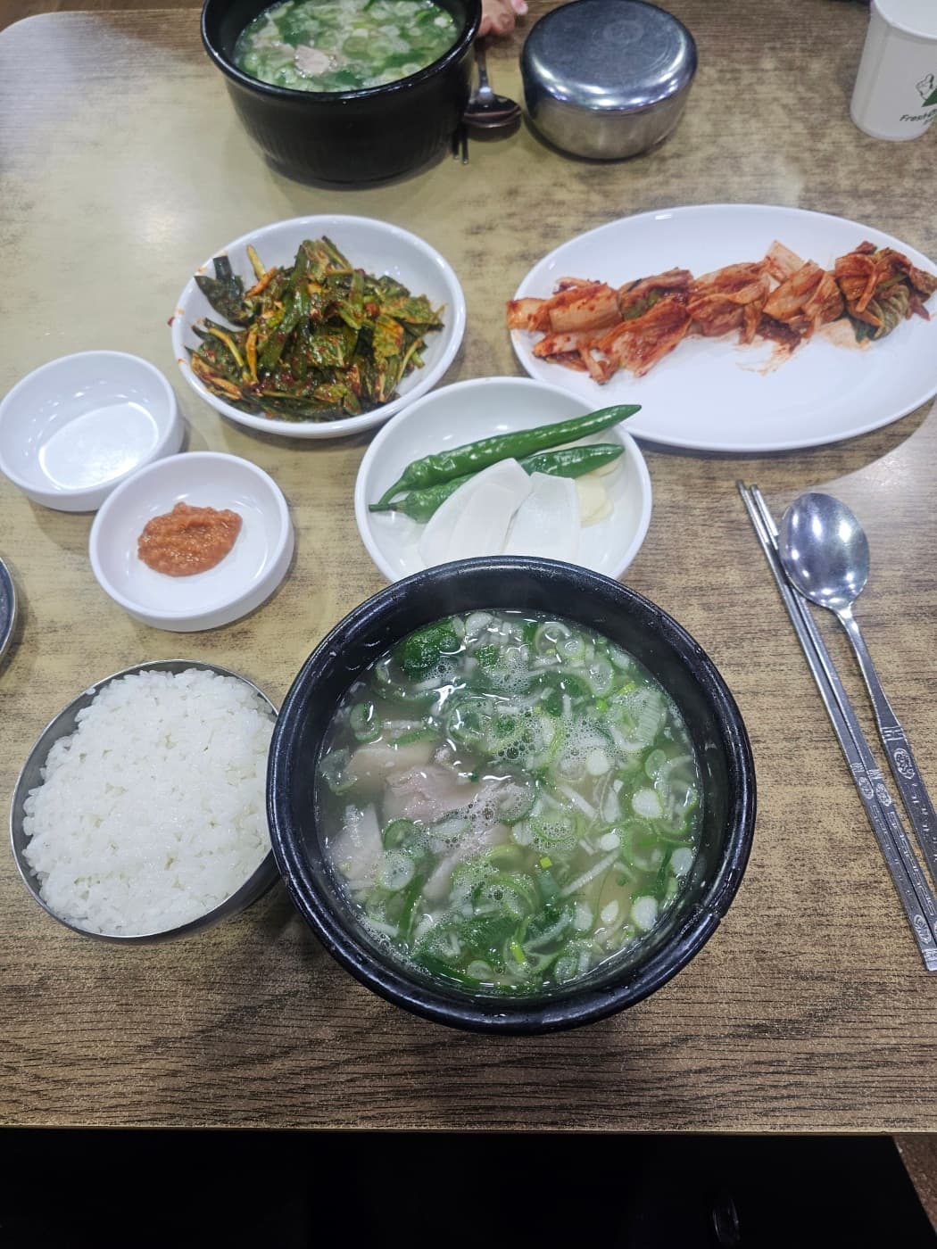 A local-style bowl of dwaeji gukbap with rice and side dishes