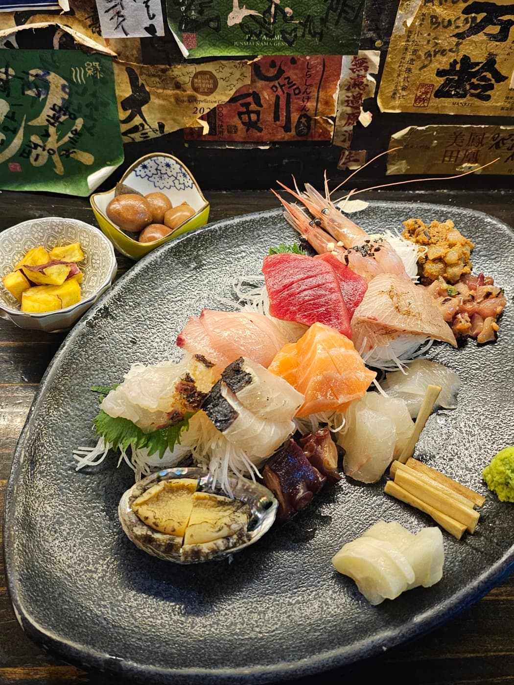 Assorted seafood sashimi plate with shrimp, fish, and side dishes