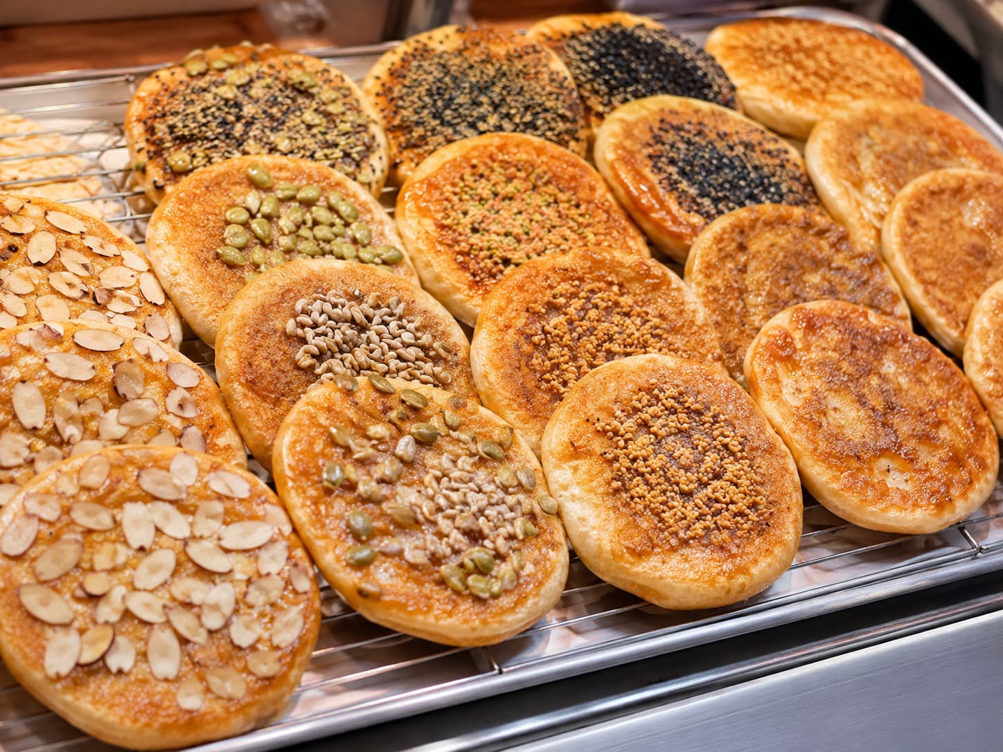Hotteok topped with a mix of crushed nuts and seeds on the outside.